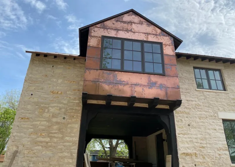 Copper metal panel facade on a stone building for Roof Repair in Emmett